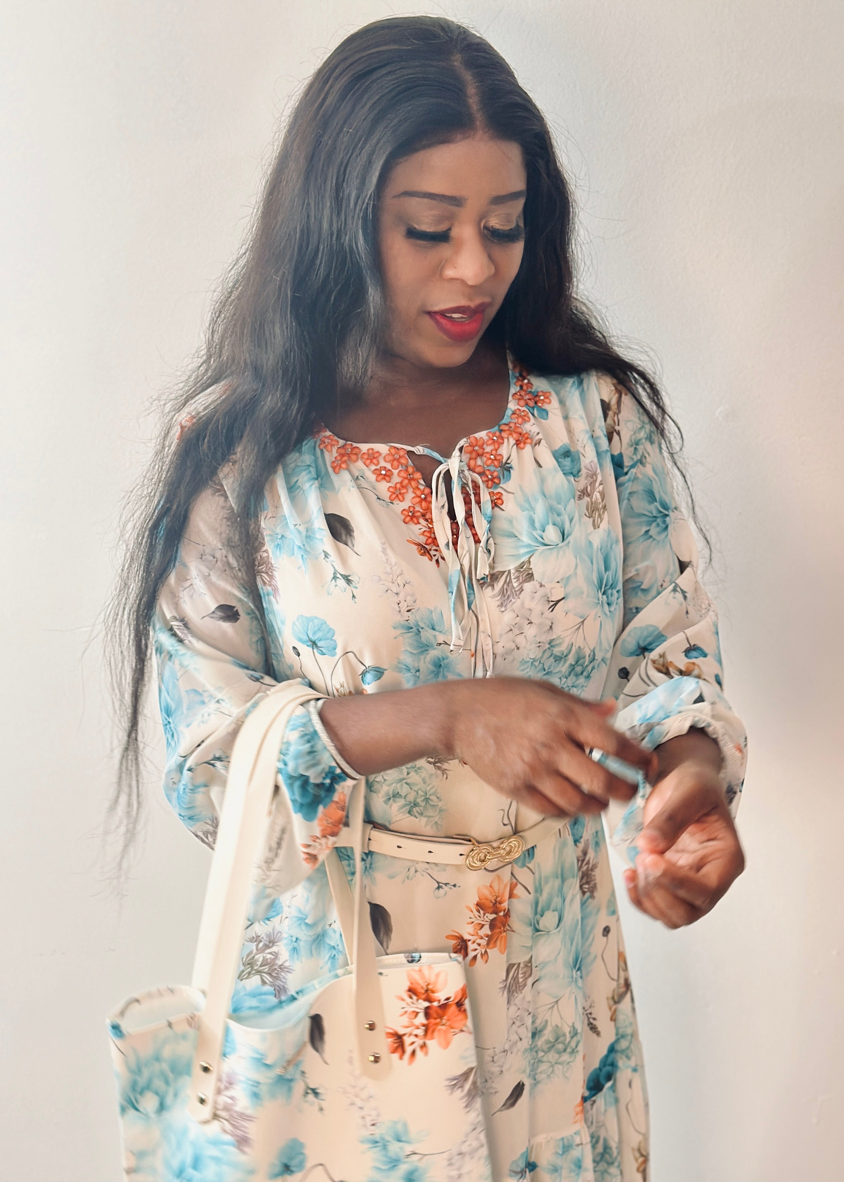 Model wearing the Grace Floral Maxi Dress featuring a soft floral print in aqua blue, coral, and cream tones.