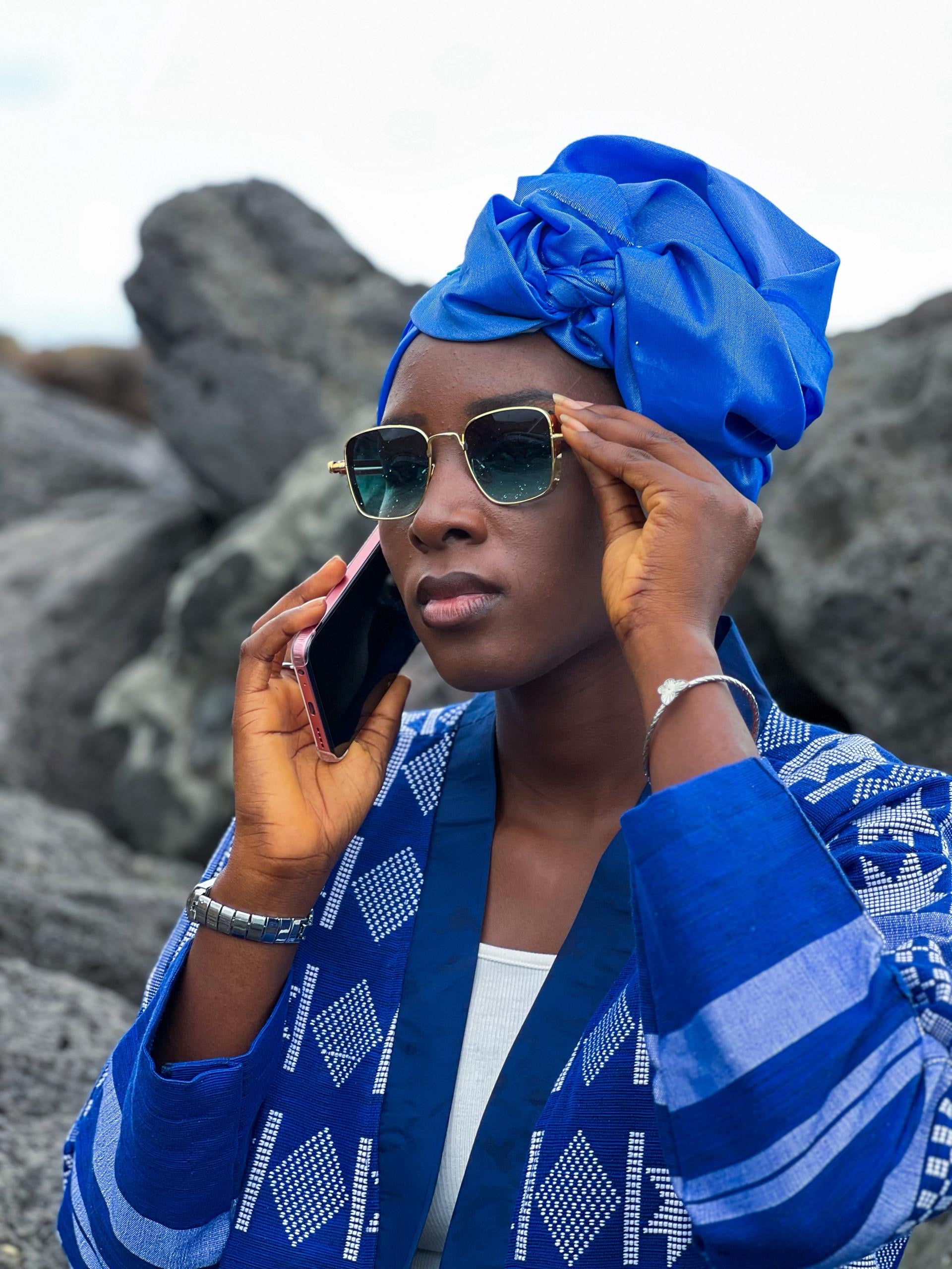 Kanoo Hand Woven Jacket worn by a woman with sunglasses and blue headwrap while on the phone.